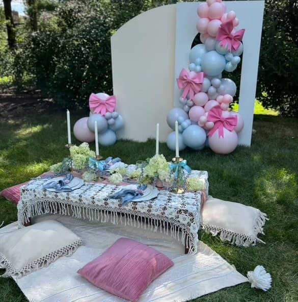 M&M Event Decor outdoor celebration with a styled table, flowers, and pastel balloon backdrop